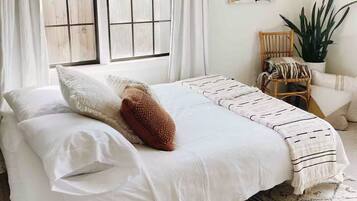 Tabla de planchar con plancha y ropa de cama