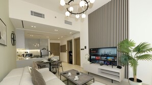 A modern living room with a sofa, coffee table, TV, and a dining area. - Chic 1BR with Private Terrace & Burj Khalifa Skyline View | 4 Guests (Dubai)