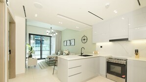A modern kitchen with a central island, stainless steel appliances, and a dining area with a view. - Chic 1BR with Private Terrace & Burj Khalifa Skyline View | 4 Guests (Dubai)
