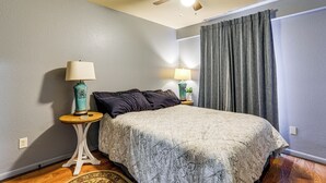 A bedroom with a bed, two bedside tables with lamps, a ceiling fan, and a window with curtains. - Near Universities & LR: Family Apt in McRae, Ark (McRae)