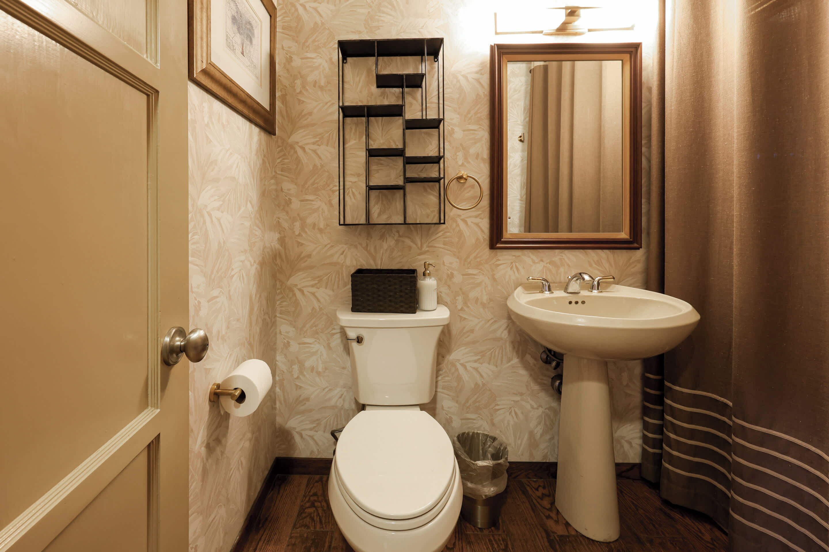 Une salle de bain avec des toilettes, un lavabo et un miroir.