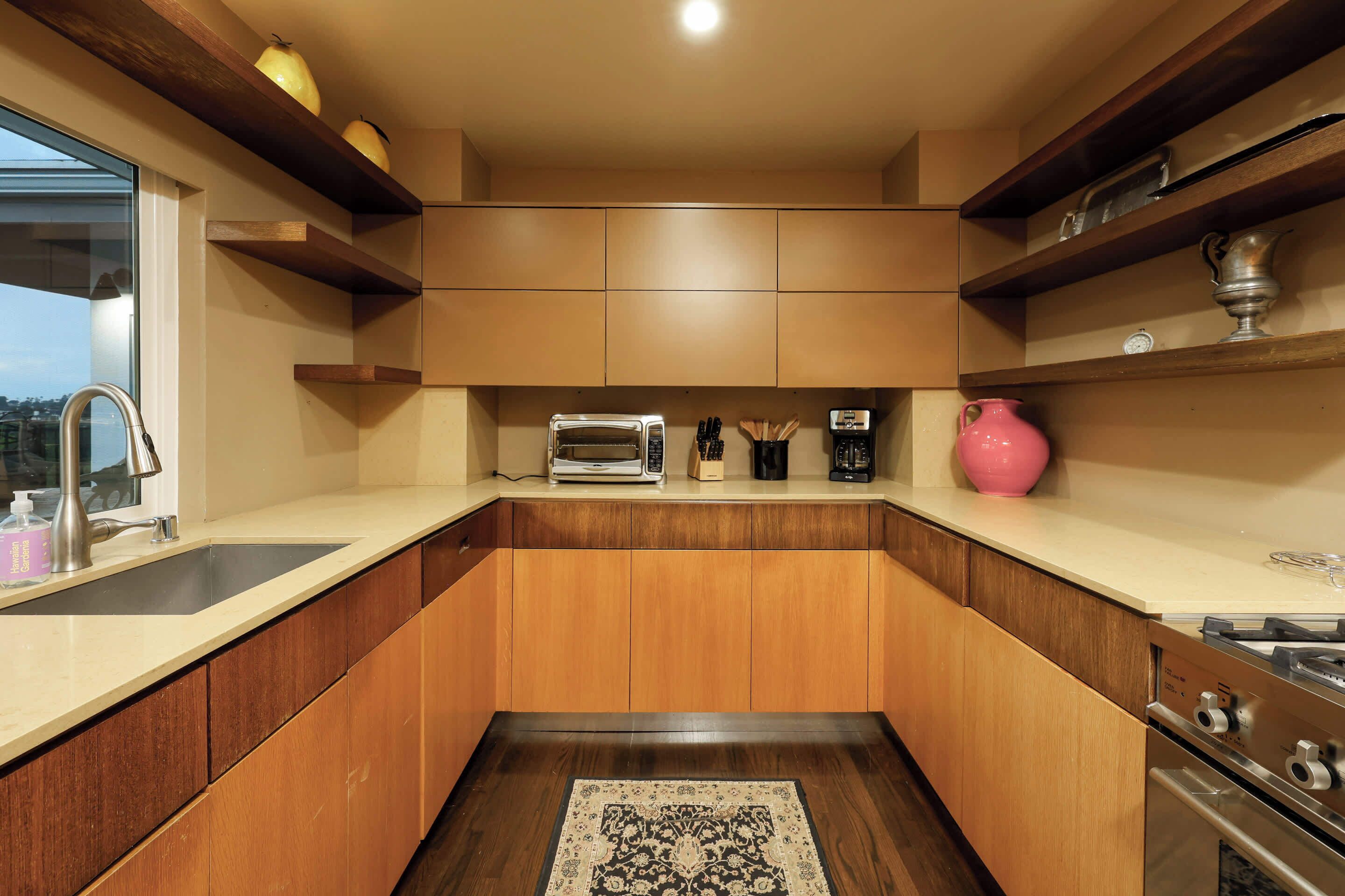 Una cocina moderna con armarios de madera, horno empotrado y cafetera.
