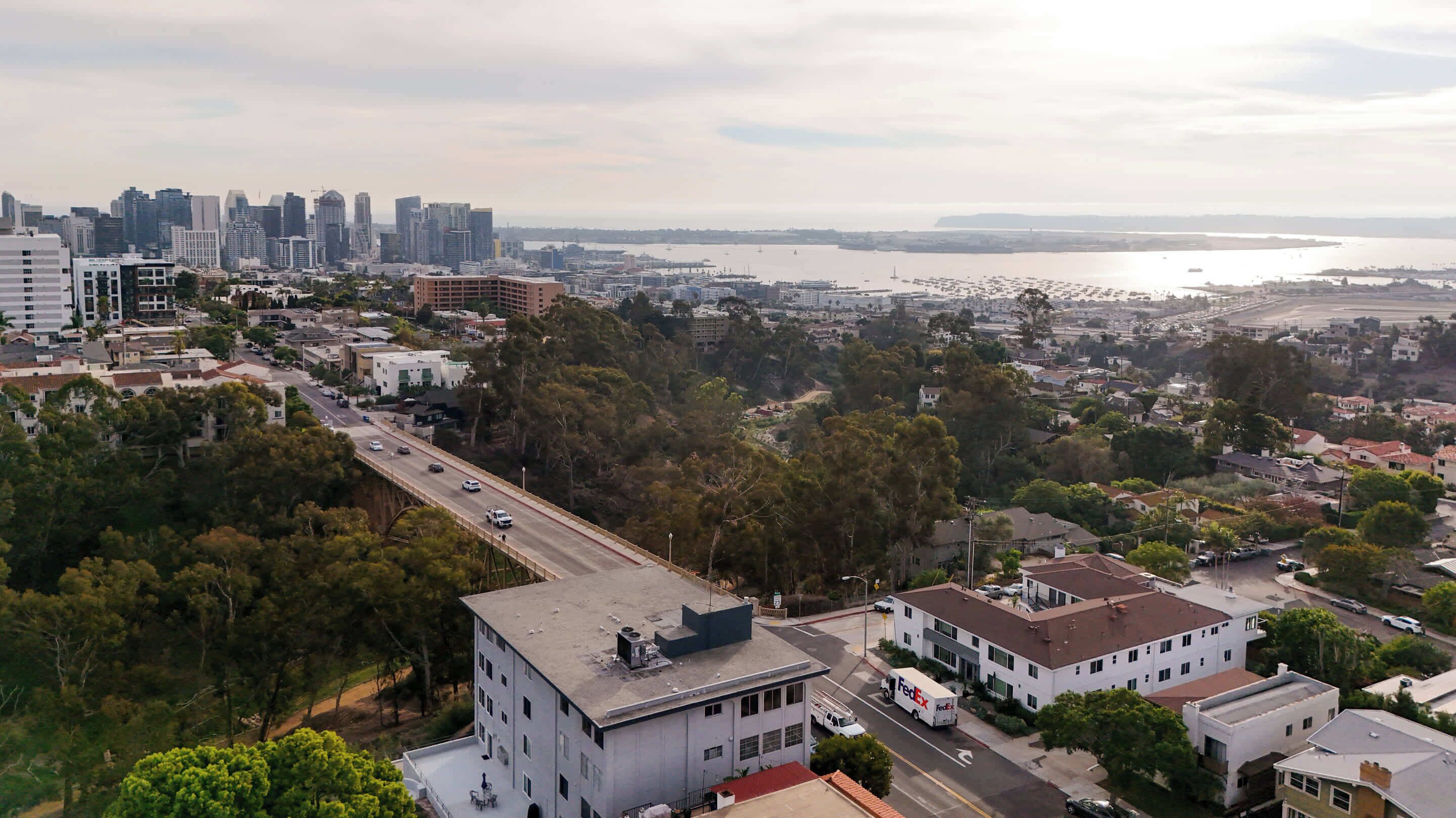 A cityscape with a prominent bridge, dense urban buildings, and a waterfront.