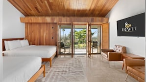 A hotel room with a wooden ceiling, two beds, a seating area with a sofa and chairs, and a sliding glass door leading to an outdoor area.