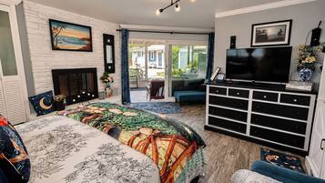 Quarto com cama, televisão, penteadeira e lareira.