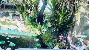 A pond with rocks and plants, surrounded by greenery. - THE KOI PONDS RETREAT 3k Sqft OUTDOORS + Kitchen, 2Bd 1 Ba Mstr Suite & Casita (Fullerton)
