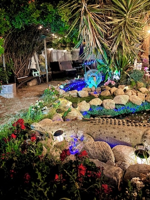 A garden with a pond, rocks, and various plants. - KOI PONDS RETREAT 3K SqFt VILLA Outdoor Kitchen~Living 2B1Ba MASTER SUITE+CASITA (Fullerton)