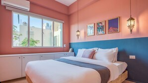 A bedroom with a bed, a window, a wardrobe, and wall art. - Muse 2-BR Apt in Mar Mikhael (Beirut)