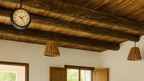 Eine Küche mit Holzausstattung, einem großen Wasserspender, einer Kaffeemaschine und einer Uhr an der Wand.