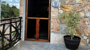 Ein Steinhaus mit einer Holztür und einem Schild mit der Aufschrift 'La Cabana de las Flores Lote 11'.