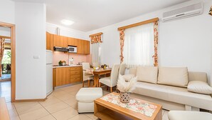 Un apartament modern amb cuina, zona de menjador i saló.