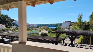 A balcony with a view of a lake, buildings, and greenery.