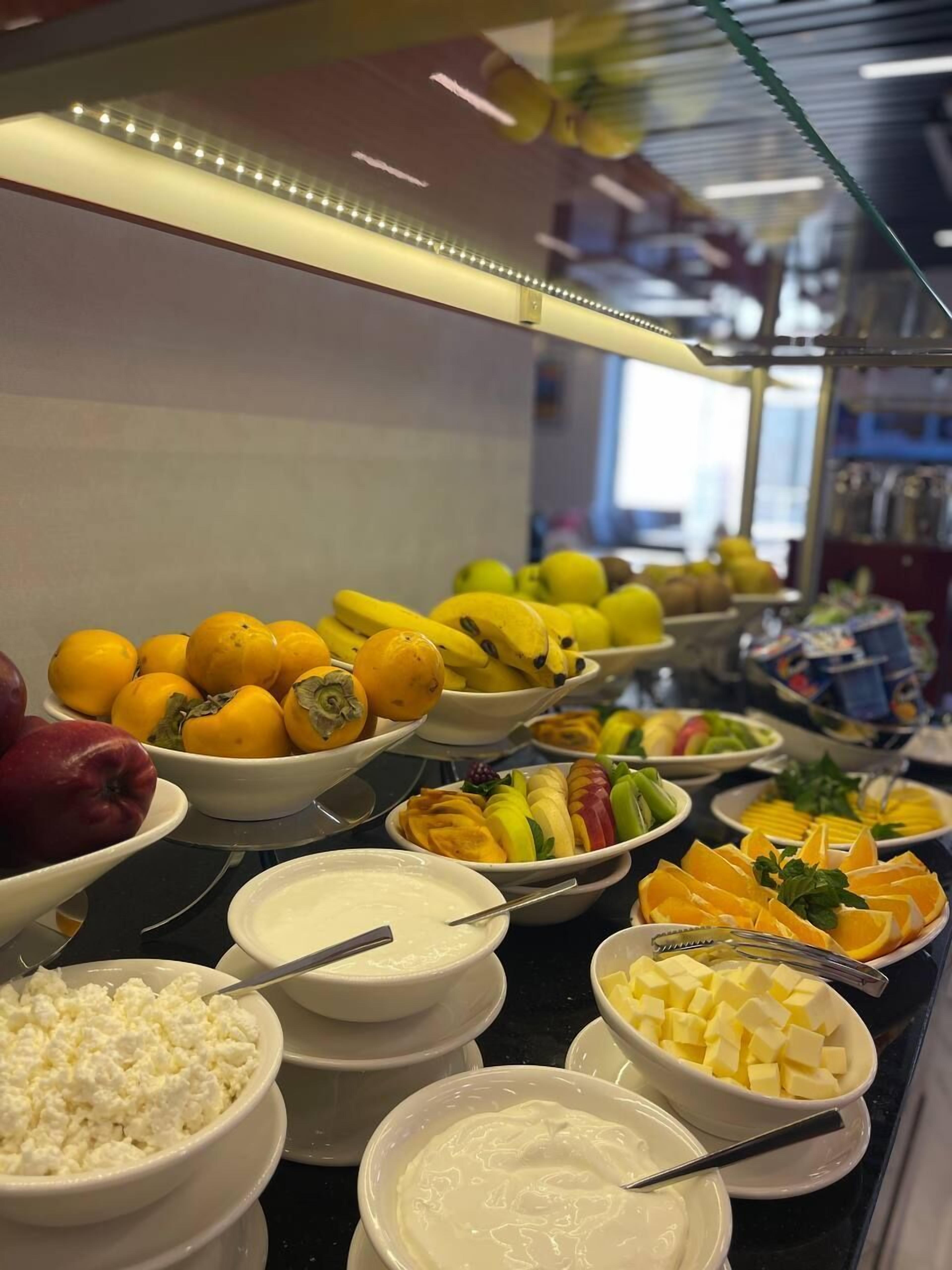 A buffet with various fruits, cheeses, and dips.