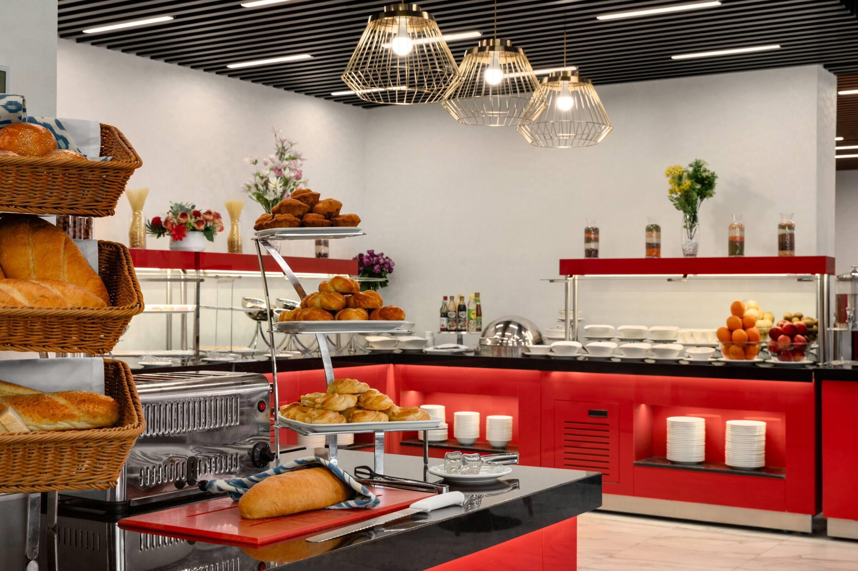 Un buffet proposant du pain, des viennoiseries et des fruits.