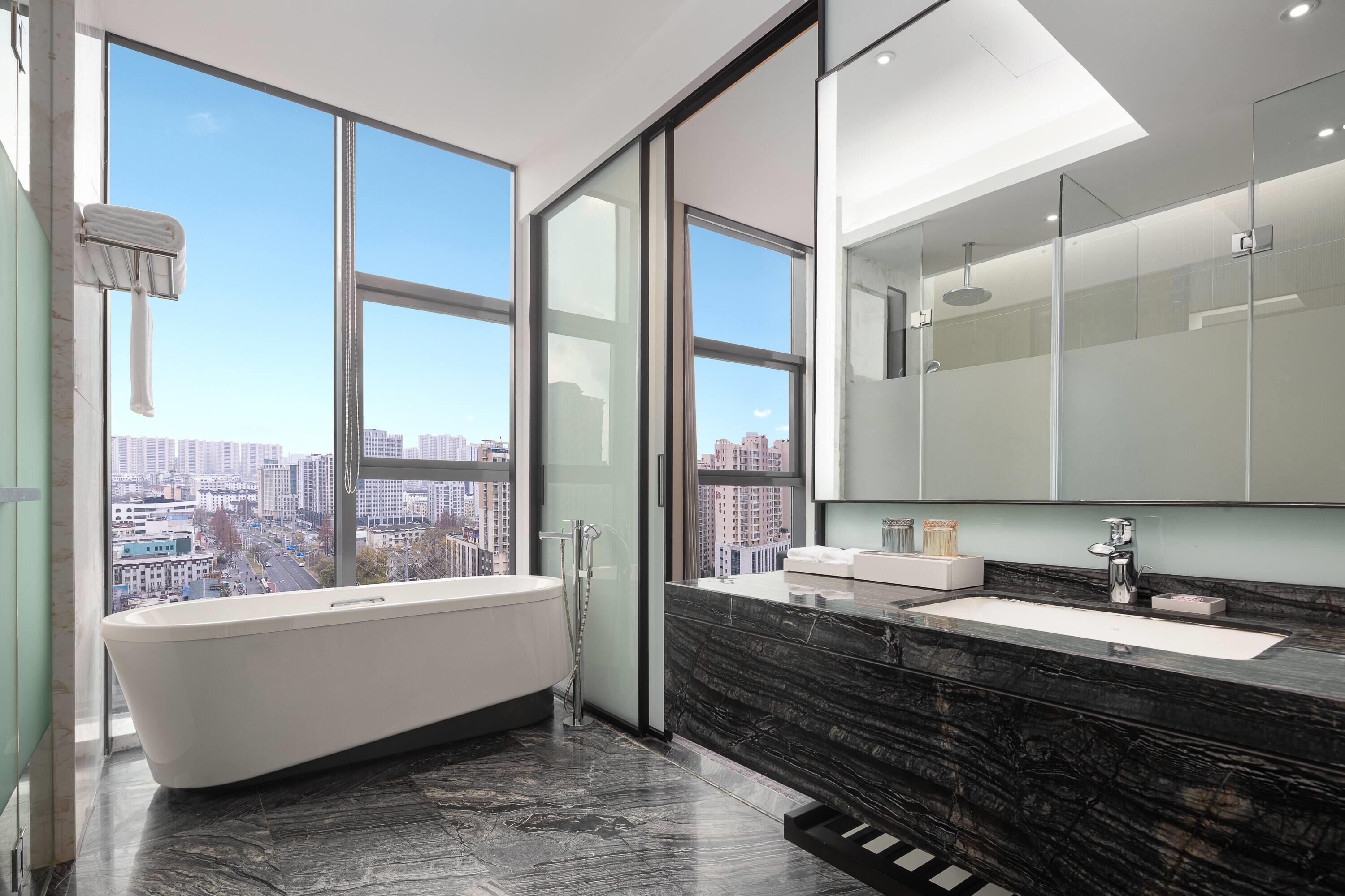 Une salle de bain moderne avec une baignoire, un lavabo et un grand miroir.