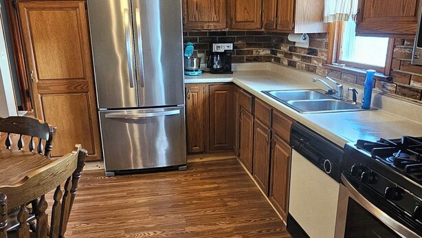 A kitchen with wooden cabinets, a stainless steel refrigerator, a gas stove, and a ceiling fan. - Smitty's Cozy Corner in Smethport, PA. Spaciously 4-bedroom home (Smethport)