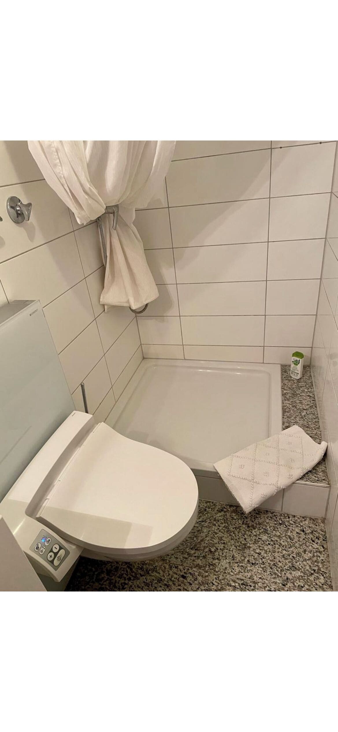 A bathroom with a toilet, a bathtub, and a shower curtain.