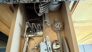 A drawer with various kitchen utensils including a grater, a can opener, and a pair of scissors. - Chic Serenity Loft / Fast Wi-Fi Walkable (Cleveland)