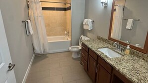 Et badeværelse med brusebad, toilet og vask.