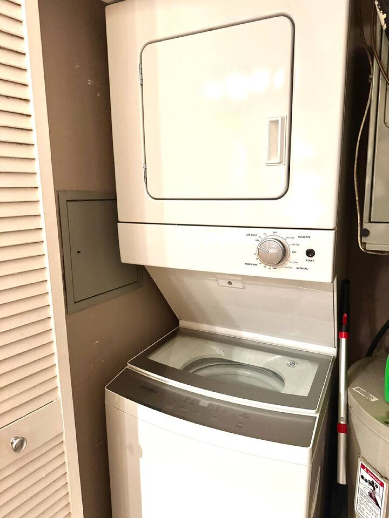 A compact, white, front-loading washer and dryer unit with a control panel and a small storage compartment below.