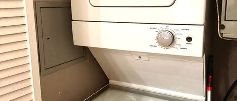 A compact, white, front-loading washer and dryer unit with a control panel and a small storage compartment below.