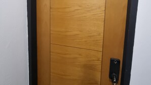 Eine Holztür mit der Nummer 204, einem schwarzen Griff und einem Schlüsselloch.