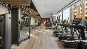 A modern gym with treadmills, weight machines, and a wooden floor. - Hyatus Curated Residences Everett (Everett)