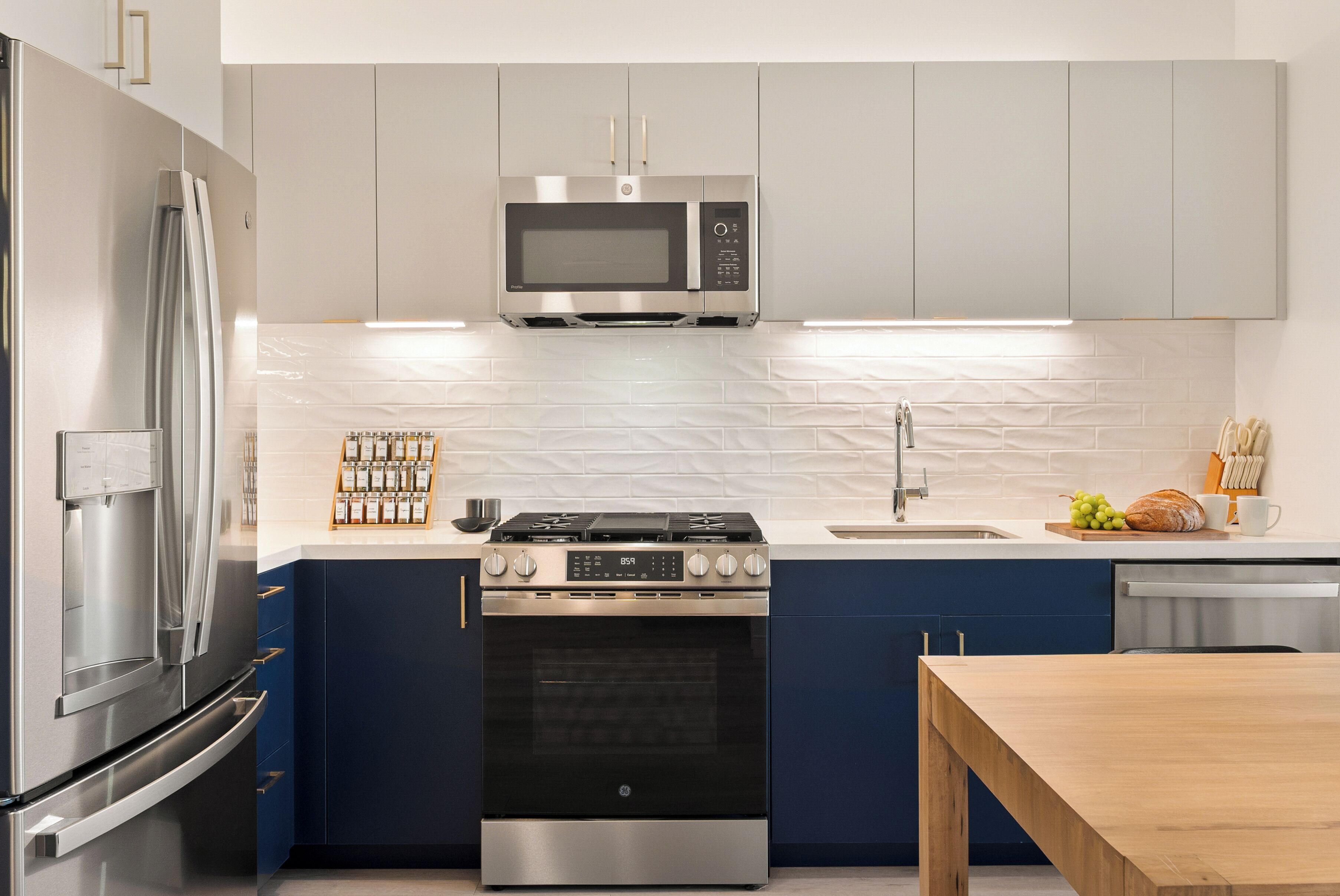 A modern kitchen with stainless steel appliances, a microwave, oven, and a sink.