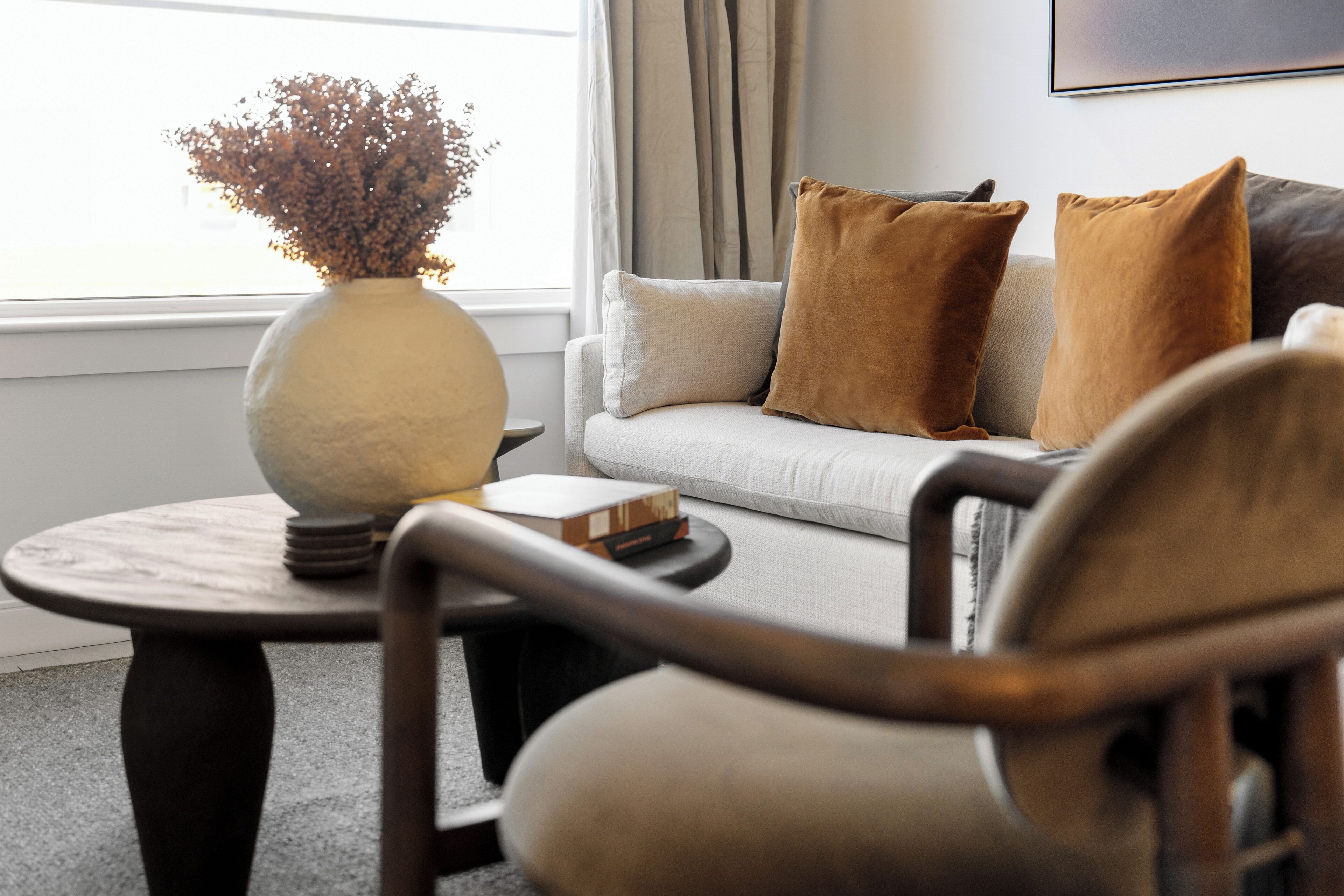 A living room with a sofa, a round coffee table, and a chair.