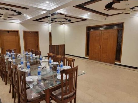 A conference room with a glass table, wooden chairs, and water bottles.