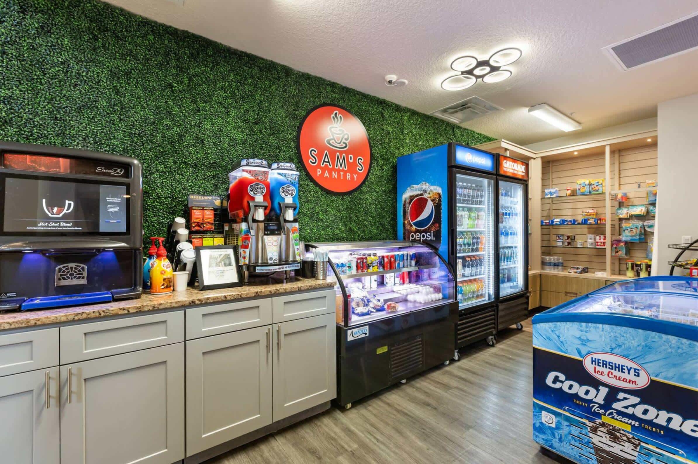 Eine Theke in einer Bäckerei mit einem Schild für 'Sam's Pantry', einem Getränkespender, einem Kühlschrank mit Pepsi und einer Kühlbox für Hershey's Eiscreme.