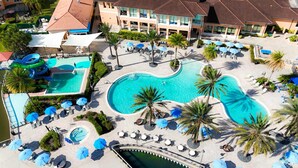Een resort met meerdere zwembaden, ontspanningszones en palmbomen.