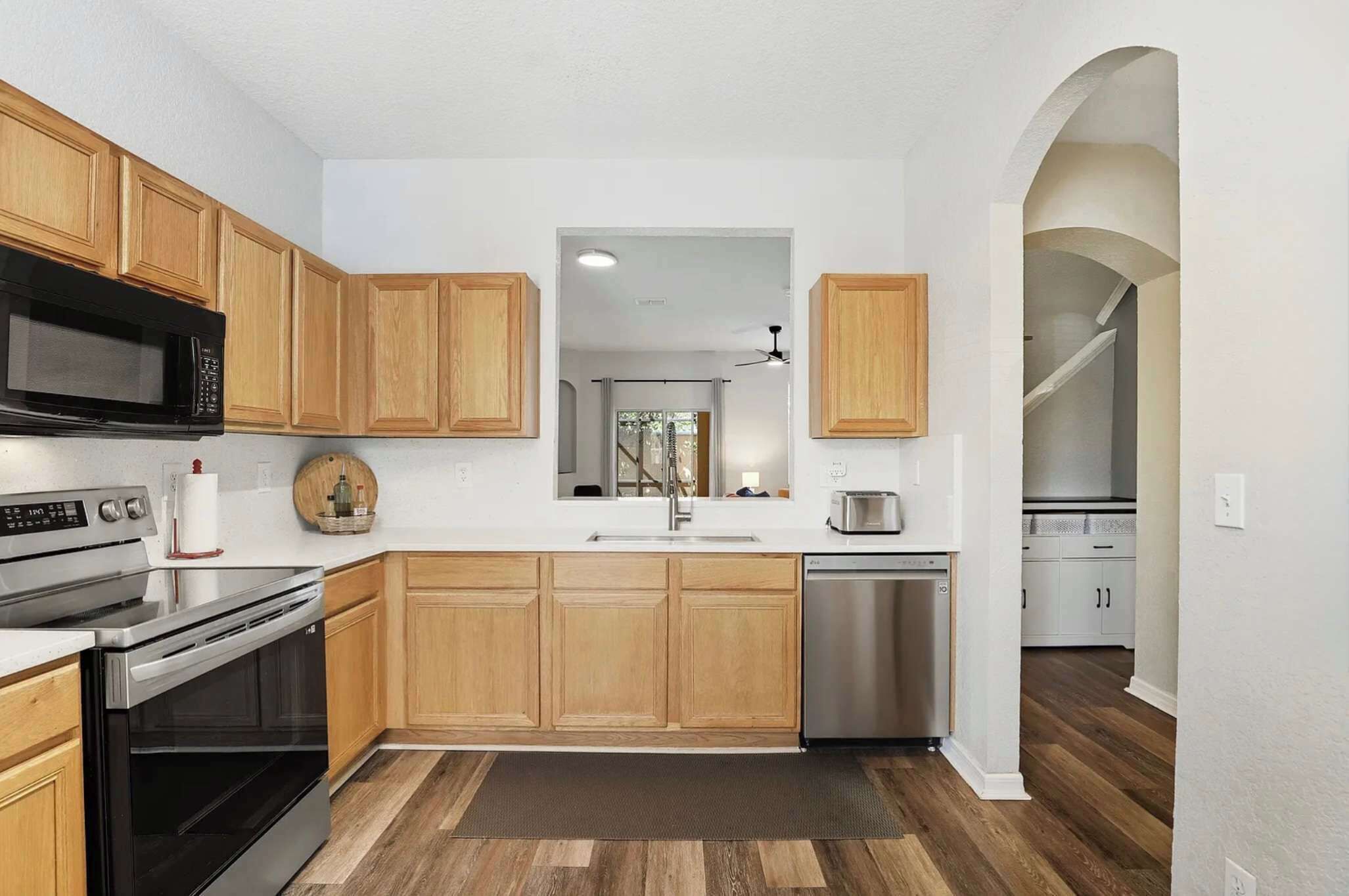 A kitchen with wooden cabinets, stainless steel appliances, and a central island.