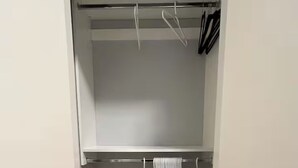 Un dressing avec une étagère supérieure grise et une étagère inférieure, toutes deux vides.