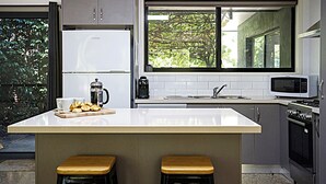 Een moderne keuken met een centraal eiland, een magnetron, een koffiezetapparaat en een spoelbak.