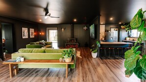 Una sala de estar moderna con un sofá verde, una mesa de centro de madera y una chimenea.