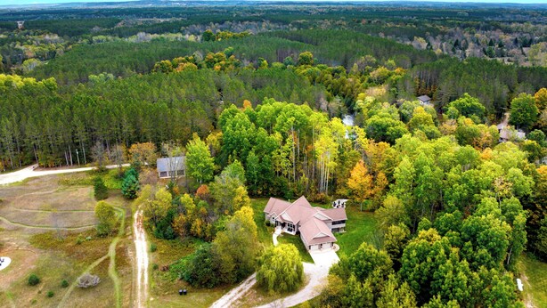 An aerial view of a large property with multiple buildings surrounded by dense forest.