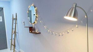 A room with a vanity mirror, a desk with a lamp, and string lights on the wall. - Mihojae Seomyeon (Busan)