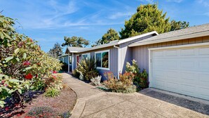 A residential property with a driveway, garage, and landscaped garden. - Charming Fort Bragg Home with Ping-Pong & Fire Pit (Fort Bragg)