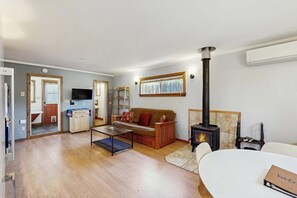 Un salon comprenant un canapé, une table basse, une cheminée et un téléviseur.