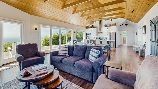 A spacious living area with a high ceiling, large windows, and a view of the outdoors. - Albion Ridge Overlook - Luxury & Modern (Albion)
