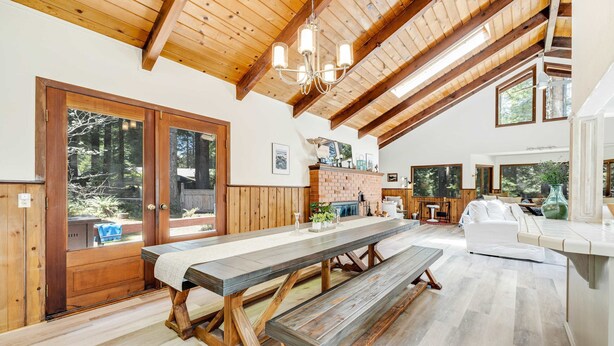 A spacious room with a large wooden table, benches, and a white sofa. - Family Getaway - Hot Tub, Fire Pit & Dog Friendly (Mendocino)