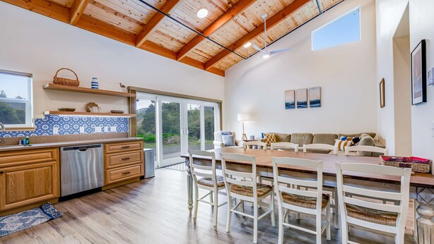 A spacious kitchen with wooden cabinets, a dishwasher, and a dining area with a wooden table and chairs.