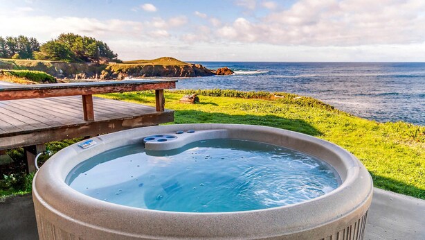A hot tub with a view of the ocean and a wooden deck. - Tideaway Private Hot Tub and Expansive Ocean View (Fort Bragg)