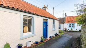 A white building with a blue door, windows, and a red-tiled roof. - Ve-Marn Cottage | Kilrenny (Kilrenny)