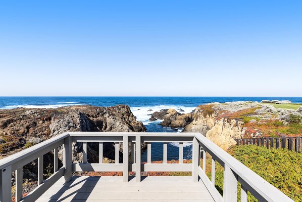 A wooden deck with a railing overlooking a rocky coastline and ocean. - Oceanfront Sanctuary - Private Cove, Deck, Grill (Fort Bragg)