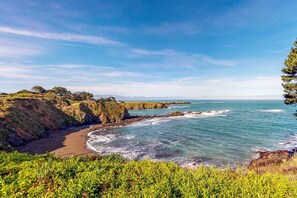 A coastal landscape with cliffs, a beach, and the ocean. - Oceanview Home with Guest Cottage & Artist Studio (Mendocino)