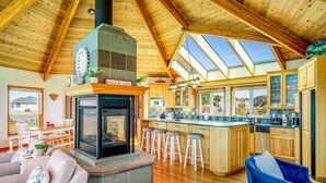 Une cuisine spacieuse avec des meubles en bois, un îlot central et une grande verrière.