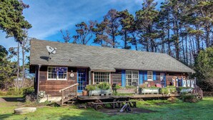 Une cabane rustique avec une façade en bois, une véranda dotée de meubles d’extérieur et une antenne parabolique sur le toit.