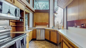 A modern kitchen with wooden cabinets, stainless steel appliances, and a dishwasher. - Oceanfront Blufftop Home - Wide Deck & Water Views (Elk)